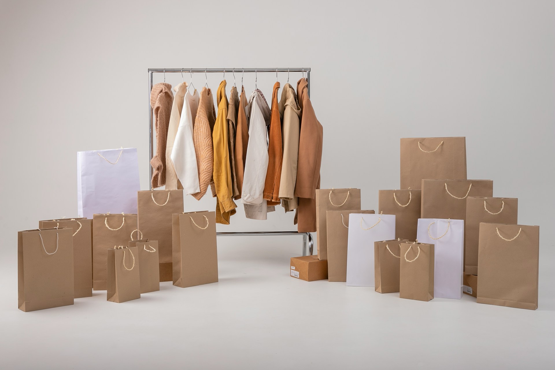 fashion apparel retail rack with shopping bags stacked in front to demonstrate sales are up in retail and how catecut can reduce returns